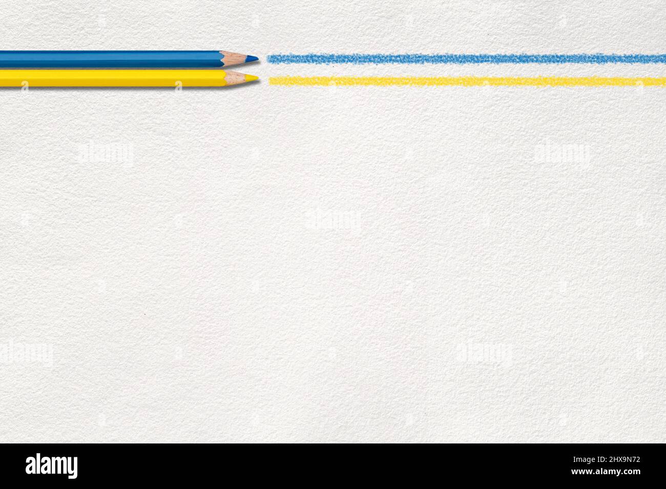 Crayon bleu et jaune dessinant une ligne sur papier en forme de drapeau de couleurs ukrainiennes. Banque D'Images