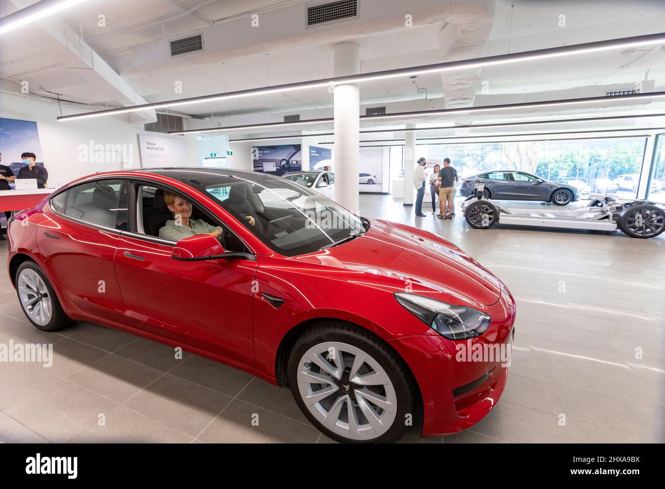 Tesla 3 car showroom dame est assis derrière le volant dans le modèle Tesla 2022 3 Banque D'Images