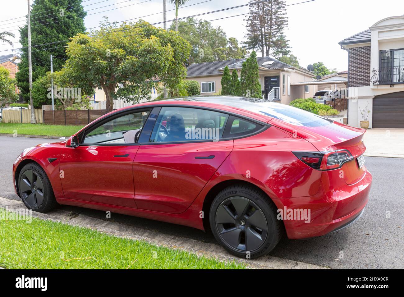 Red Tesla modèle 3, 2022 modèle 3 en rouge garée sur une rue à Sydney, Nouvelle-Galles du Sud, Australie Banque D'Images
