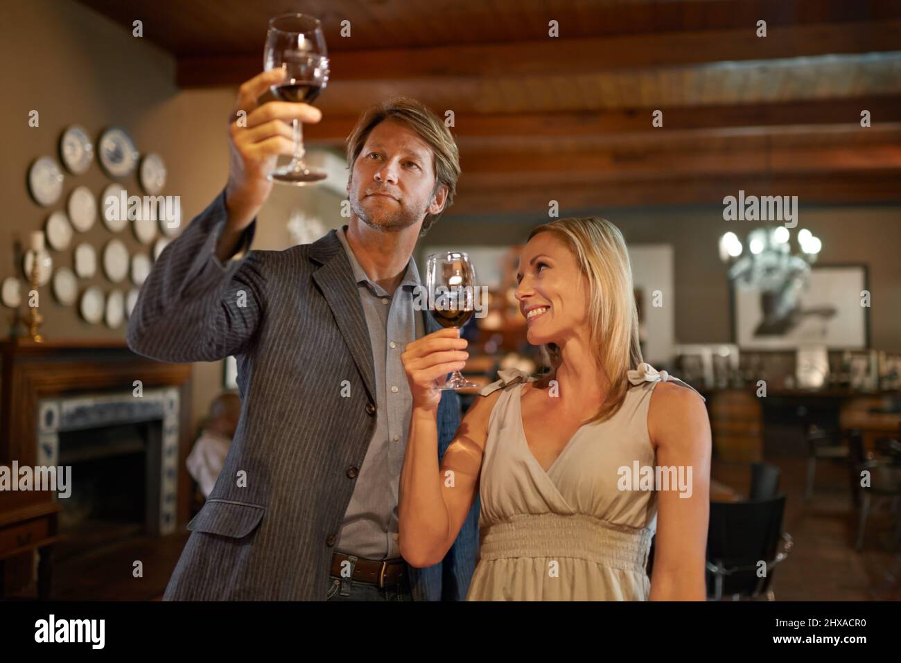 Apprécier les choses les plus fines de la vie Un couple heureux faisant une dégustation de vin dans un restaurant. Banque D'Images