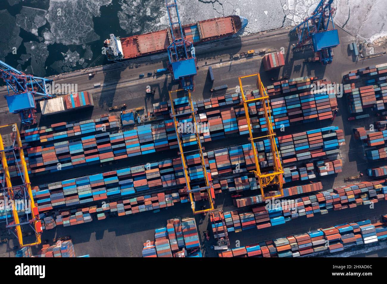Vladivostok, Russie - 27 janvier 2022 : Vue de dessus du terminal des conteneurs du port maritime. En hiver, un bateau à conteneurs est en train de charger au quai. Banque D'Images