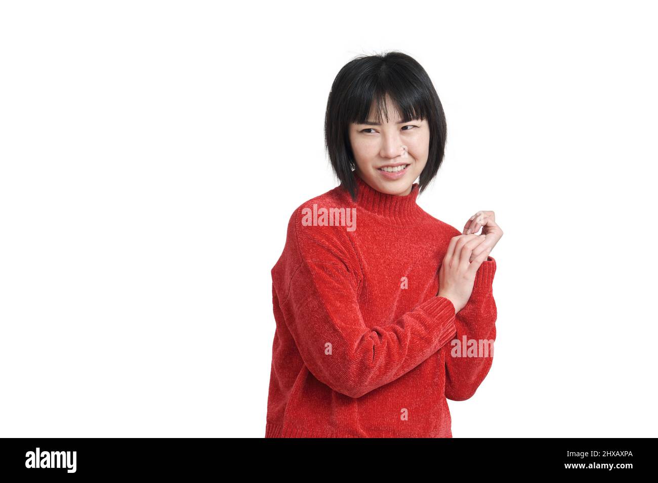 Jeune femme asiatique à l'expression dégoûtée portant un chandail rouge, isolée. Banque D'Images