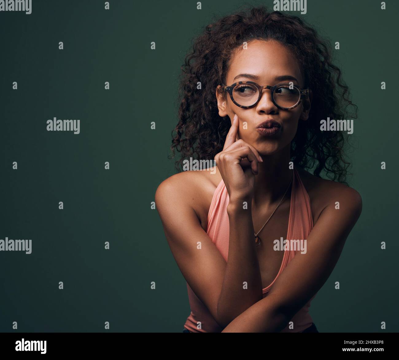 Pas seulement un joli visage. Photo courte d'une jeune femme attrayante et originale se posant sur un fond vert en studio. Banque D'Images
