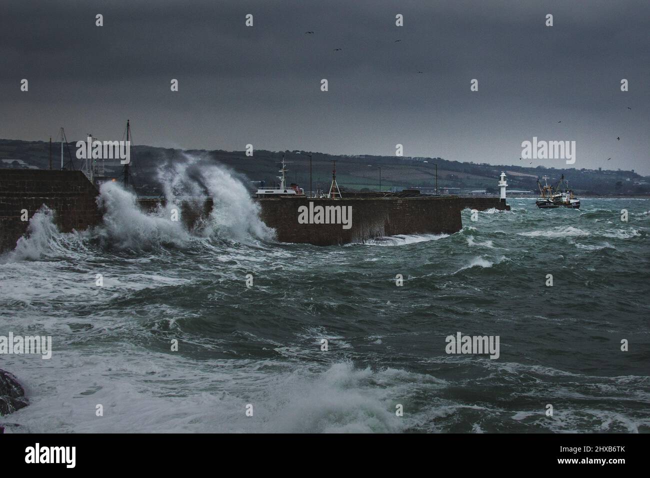 Un chalutier à faisceau de la flotte de pêche de Newlyn bascule fortement dans les mers accidentées comme elle met dans le port de Penzance pour des réparations. Banque D'Images