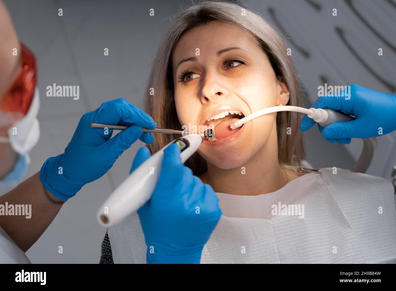 Soins dentaires lumière bleue concept - Portrait d'une belle femme souriante au cabinet du dentiste Banque D'Images