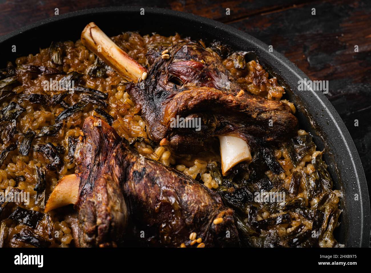 Jarrets d'agneau braisés avec sauce et herbes, sur fond de table en bois sombre Banque D'Images