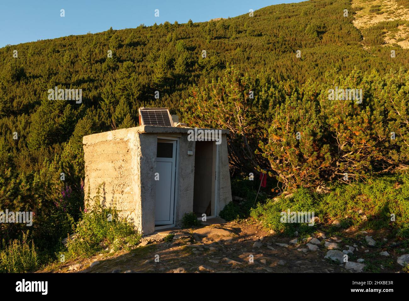 Toilettes extérieures simples en béton avec un mini panneau solaire installé dans le parc national et réserve de Pirin, montagne de Pirin, Bulgarie, Balkans, Europe Banque D'Images