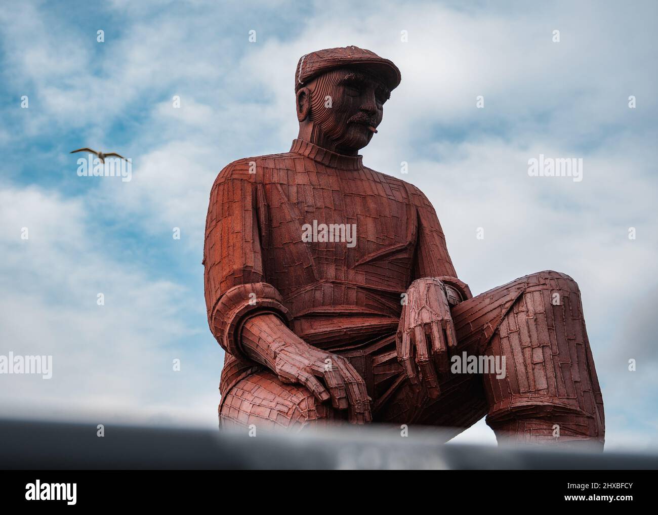 Un gros plan de la statue du mémorial vert du Fiddler avec un mouette en arrière-plan, North Shields Banque D'Images