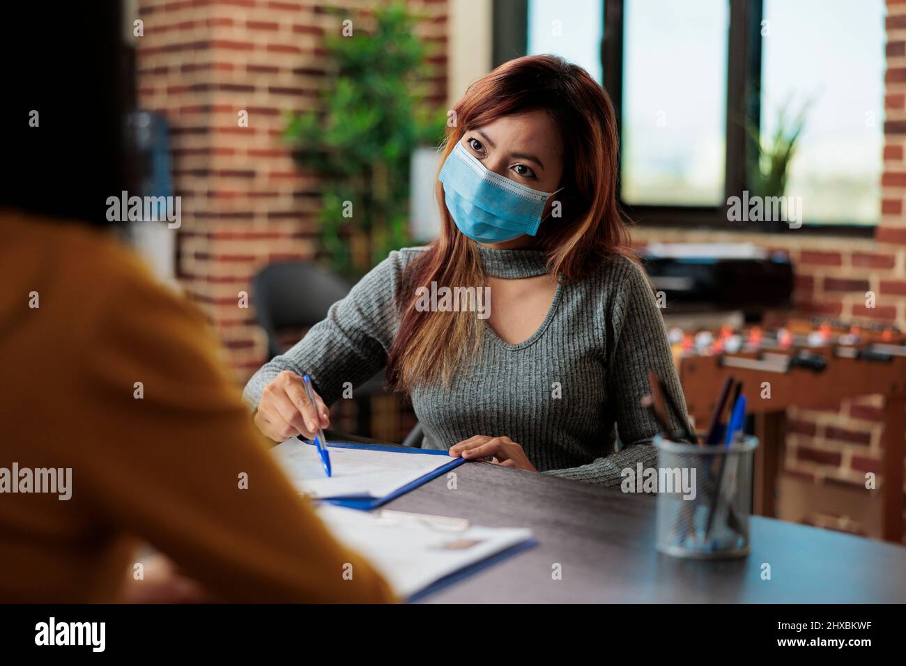 Femmes d'affaires portant un masque médical pour prévenir l'infection avec covid19 travaillant au plan d'affaires dans le bureau de démarrage. Collaborateurs collaborant au cours d'un projet marketing discutant de la stratégie de gestion Banque D'Images