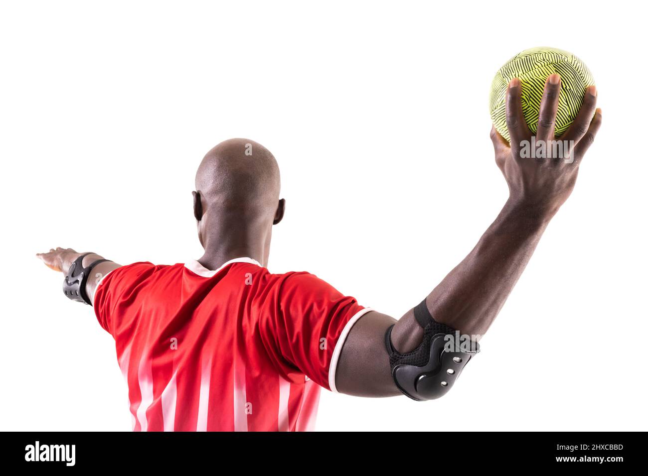Un jeune homme afro-américain jette le ballon tout en jouant le handball sur fond blanc Banque D'Images