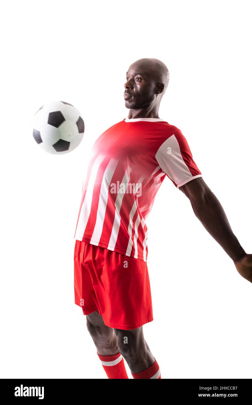 Joueur de football américain africain qualifié contrôlant le ballon avec la poitrine sur fond blanc Banque D'Images