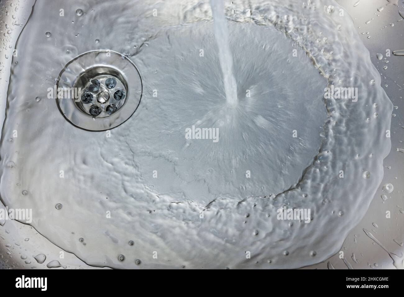 L'eau coule d'un robinet dans un évier Banque D'Images