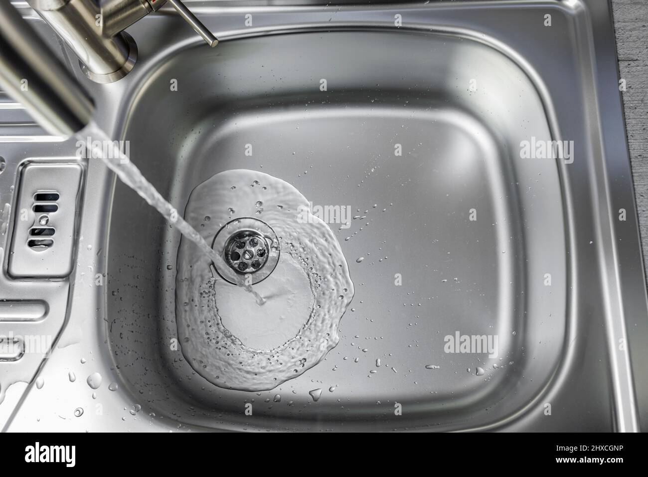 L'eau coule d'un robinet dans un évier Banque D'Images