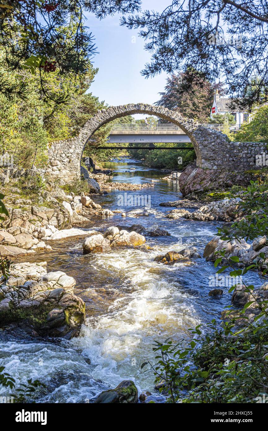 Les vestiges du pont Old Packhorse construit en 1717 et le pont routier plus moderne au-dessus de la rivière Dulnain dans le village de Carrbridge, Highland, S Banque D'Images