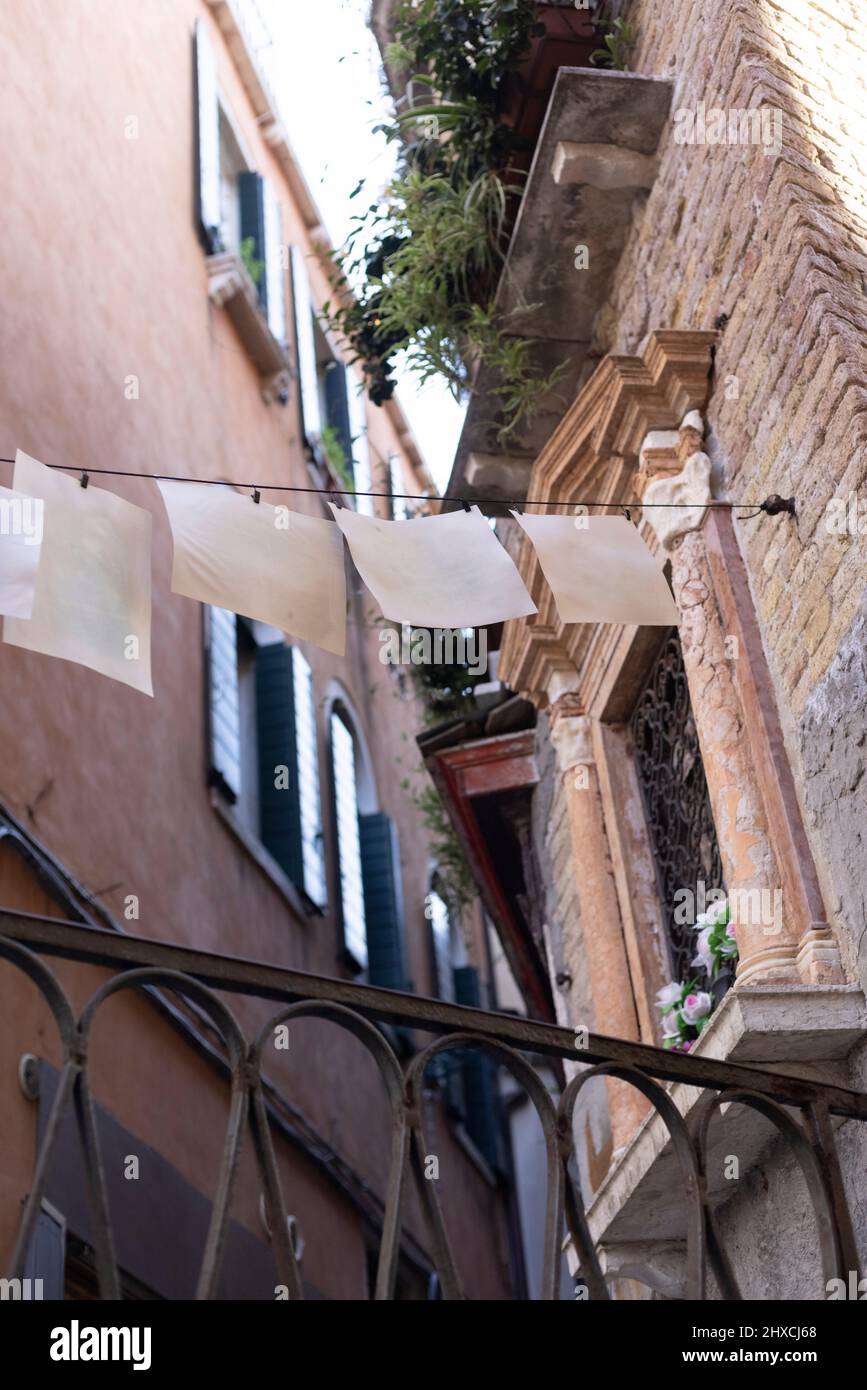 Feuilles de papier blanches sur une ligne tendue dans la vieille ville de Venise Banque D'Images