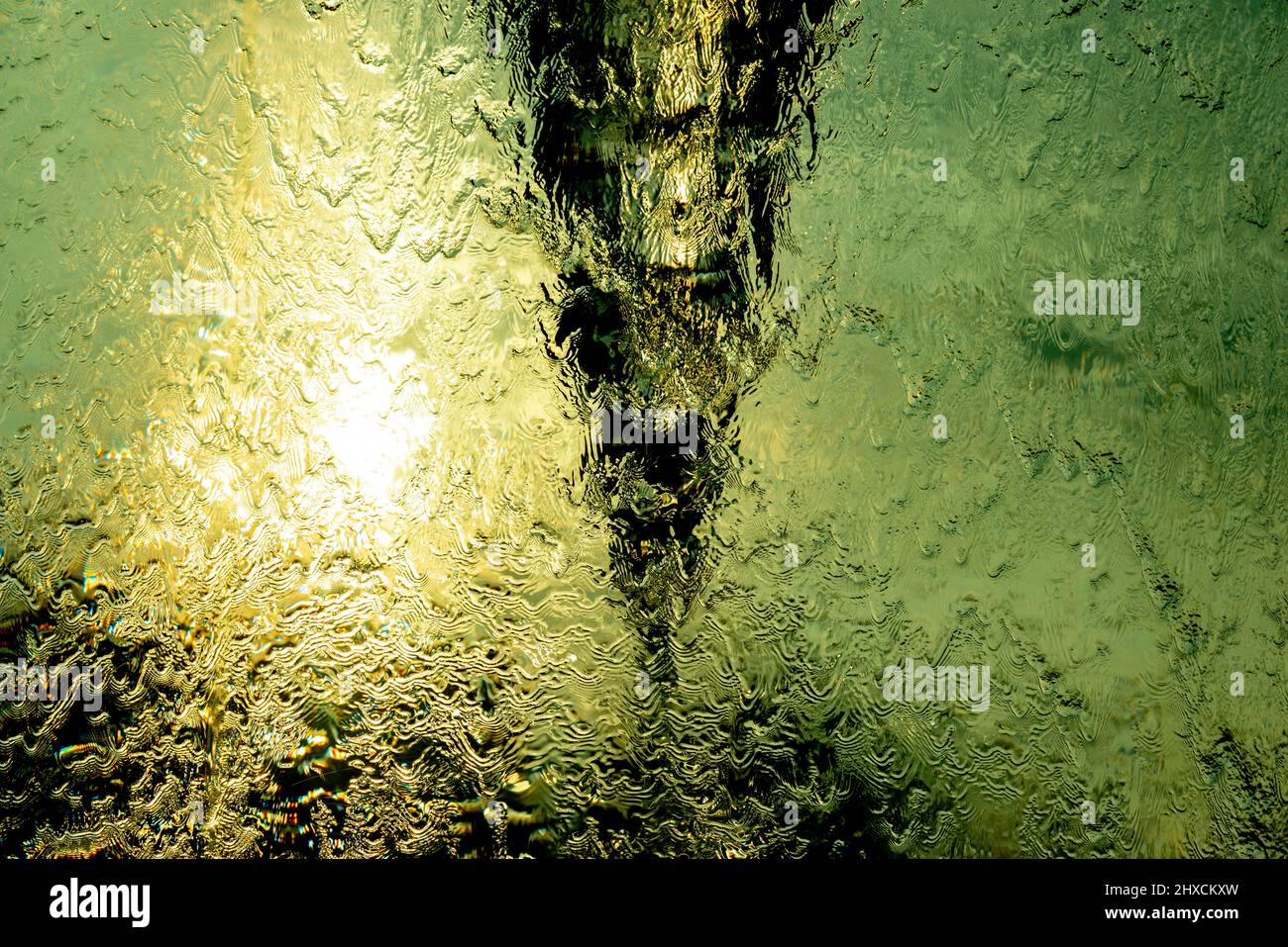 L'eau tourbillonne à contre-jour dans une fontaine, vagues sur le bord du verre, Suisse Banque D'Images