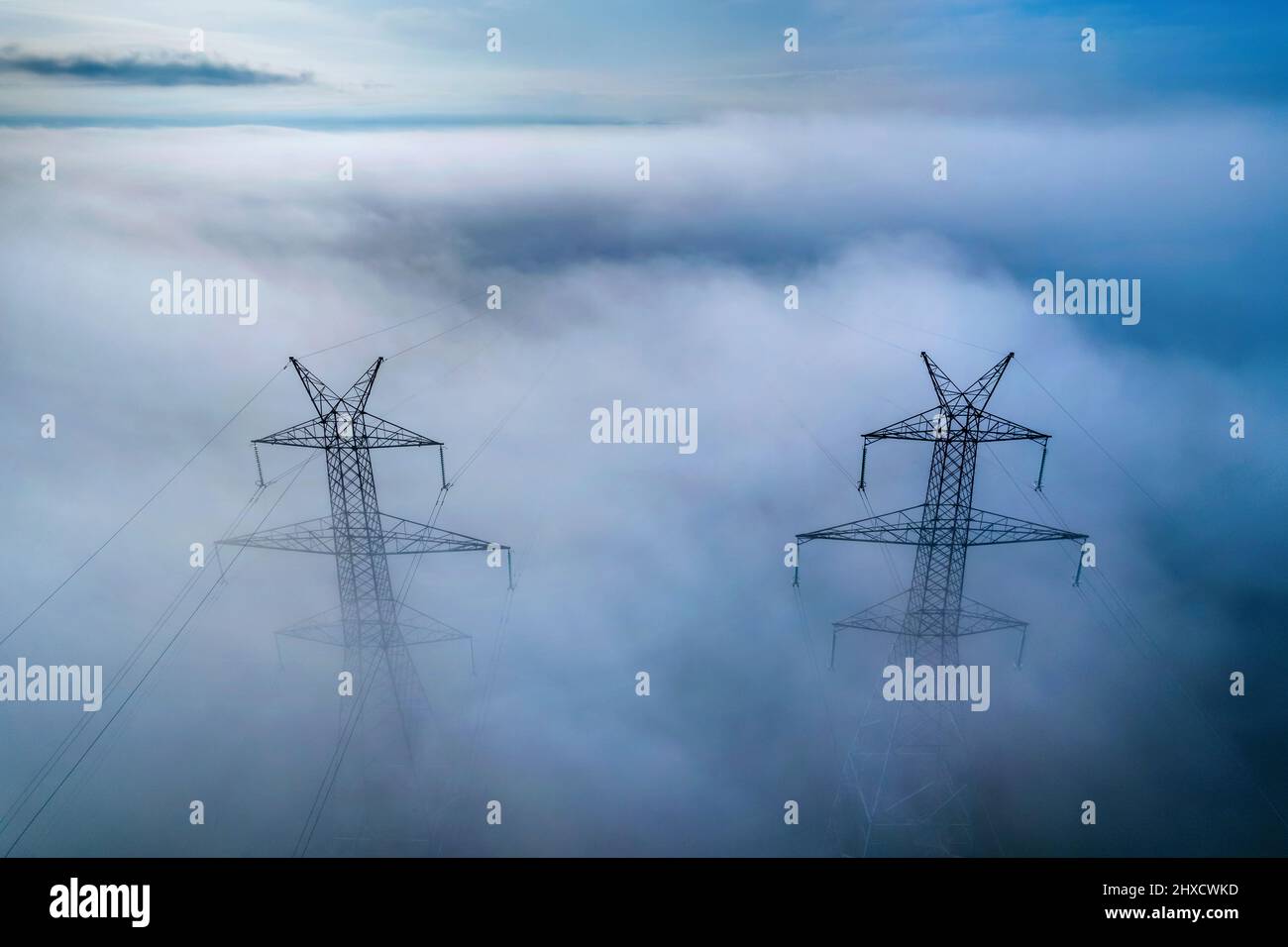 Pylônes électriques par temps brumeux, quelque part entre Tyrnavos et Amelonas, Larissa, Thessalie, Grèce. Banque D'Images