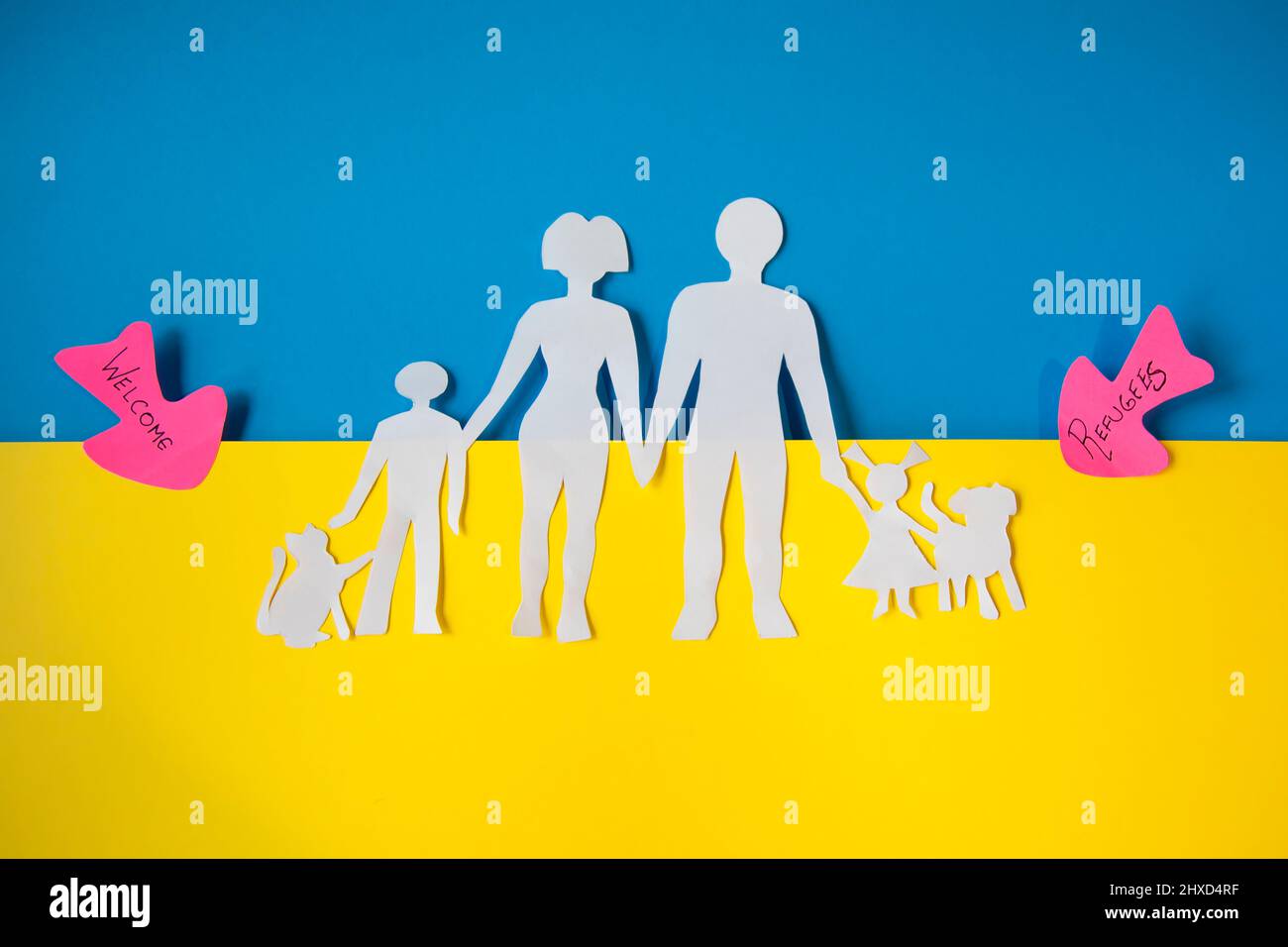 Représentation d'une famille ukrainienne dans l'exode pour quitter le pays. Découpe de papier sur les couleurs du drapeau ukrainien. Concept de migration. Banque D'Images