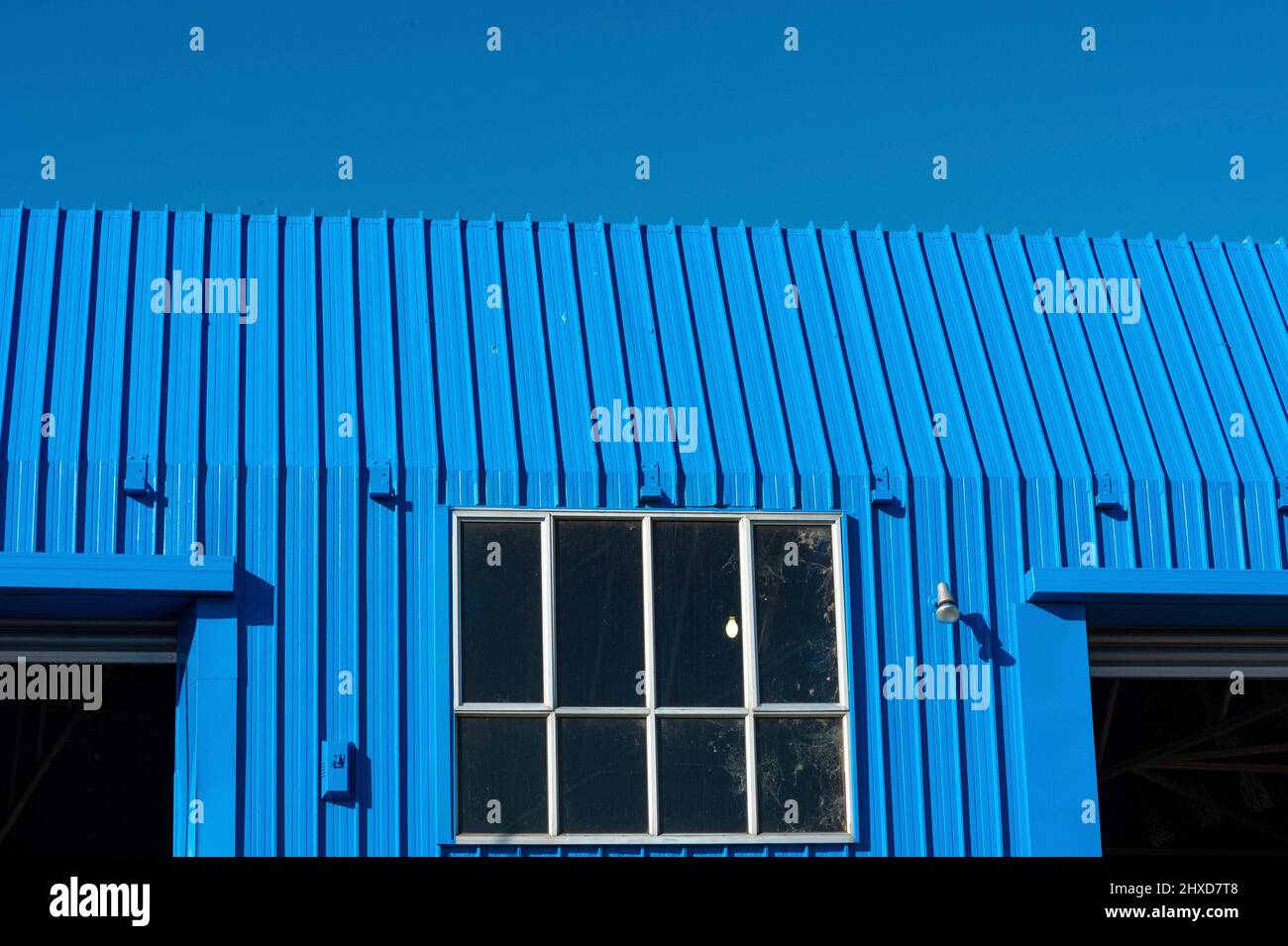 Toit métallique bleu de l'atelier contre ciel bleu intense, Blenheim, Nouvelle-Zélande Banque D'Images