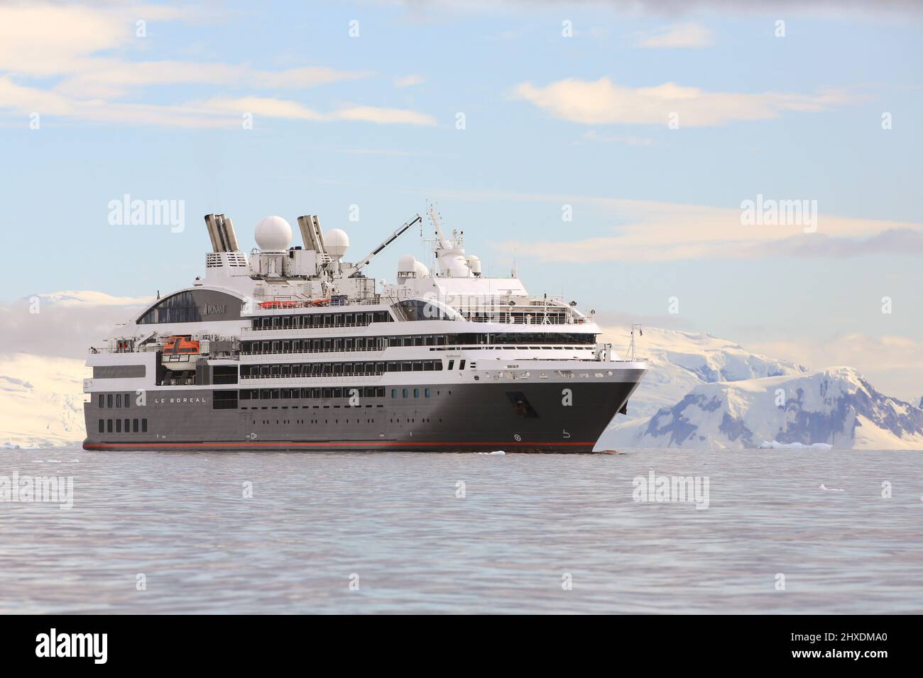 Le bateau de croisière Ponant le Boréal occupe une position dans la baie de  Wilhelmina, en Antarctique, tandis que les passagers effectuent des  excursions touristiques en bateaux du zodiaque Photo Stock -