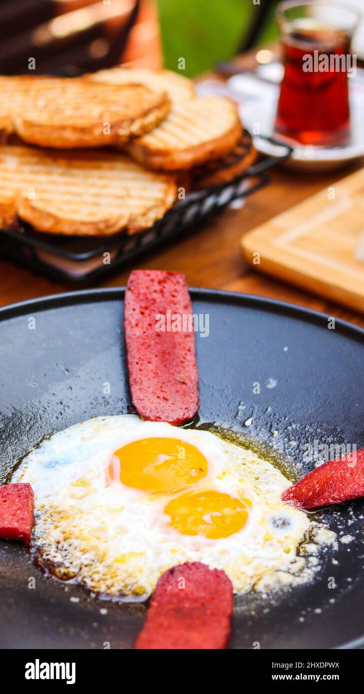 Œufs à la saucisse, pain grillé et petit déjeuner sur la table Banque D'Images