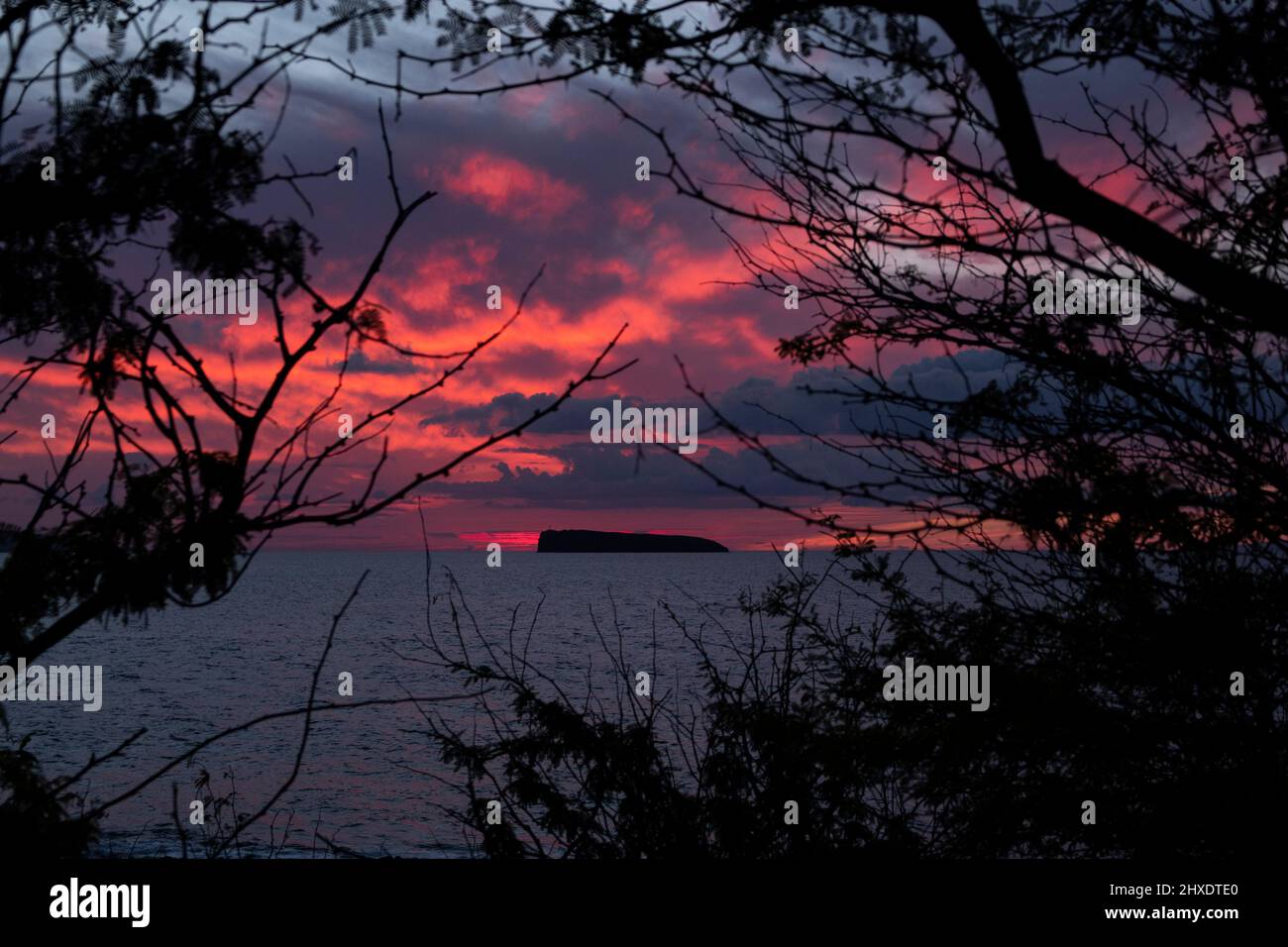 Maalaea, Maui, Hawaii, États-Unis. 7th mars 2022. Le soleil se couche derrière Molokini, est un cratère volcanique partiellement submergé en forme de croissant qui forme un petit îlot inhabité situé entre les îles de Maui et KahoÊ»olawe, dans le comté de Maui. La région est un endroit populaire de plongée et de plongée avec tuba. (Image de crédit : © K.C. Fil de presse Alfred/ZUMA) Banque D'Images