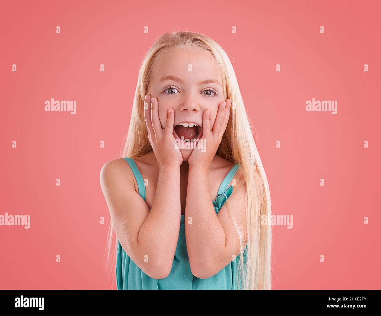 Regardez ça Photo studio d'une jeune fille posant sur un fond orange. Banque D'Images