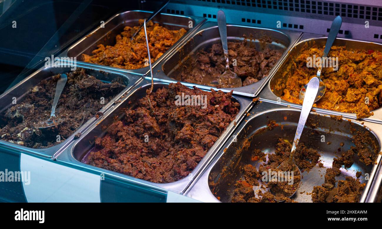 Poulet et viande de bœuf indonésiens en plateaux présentés dans un magasin indonésien toko Banque D'Images