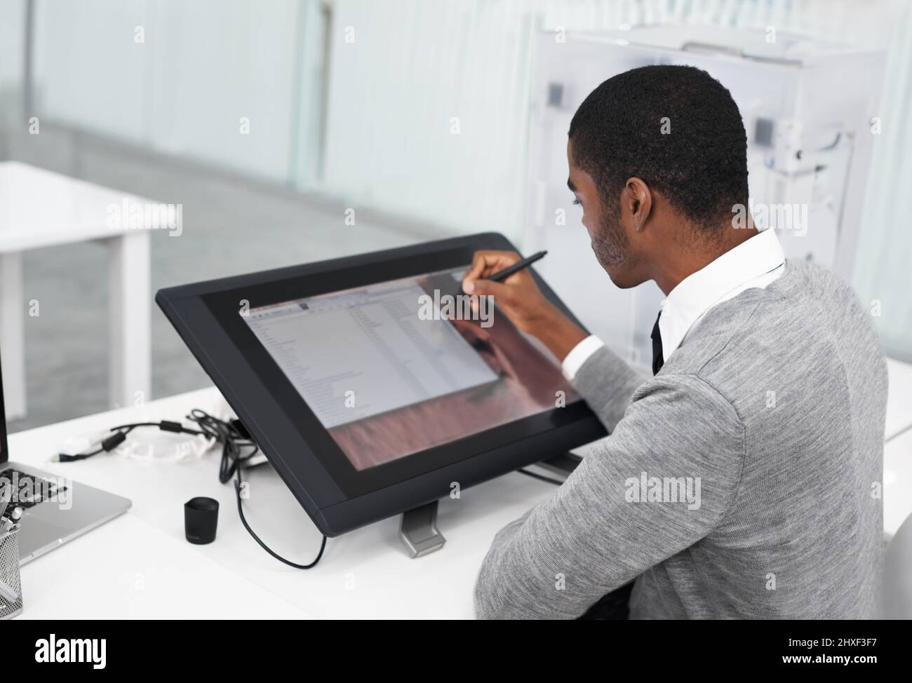 La technologie intelligente facilite tout. Un jeune homme travaillant sur un grand écran tactile. Banque D'Images