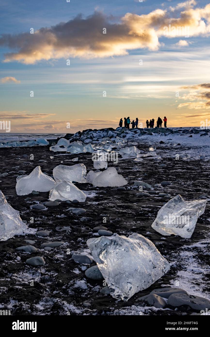 Coucher de soleil et touristes à Diamond Beach, Breidamerkursandur, sud-est de l'Islande Banque D'Images