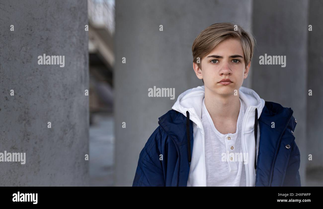Portrait d'un adolescent. Un adolescent dans une veste bleue et un t-shirt blanc regarde la caméra. Banque D'Images