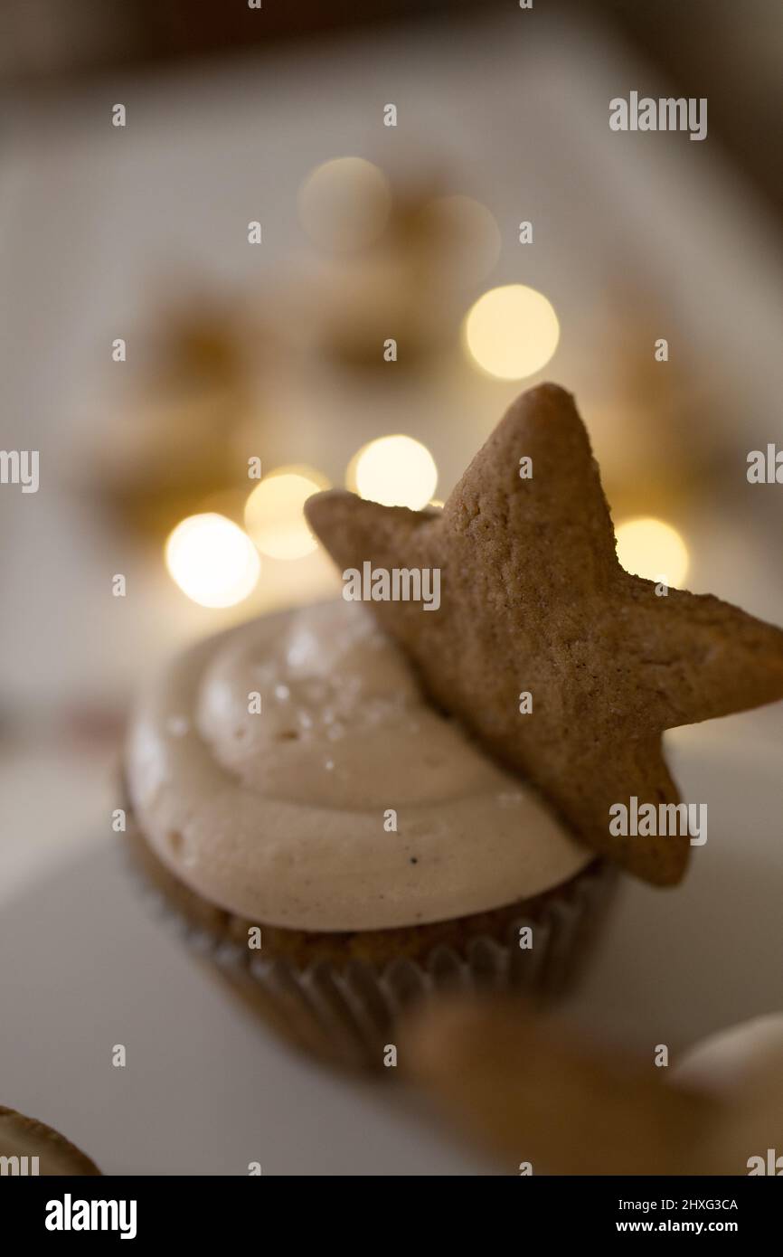 Cupcake avec décoration de biscuit d'étoile, lumières scintillantes, nappe blanche Banque D'Images