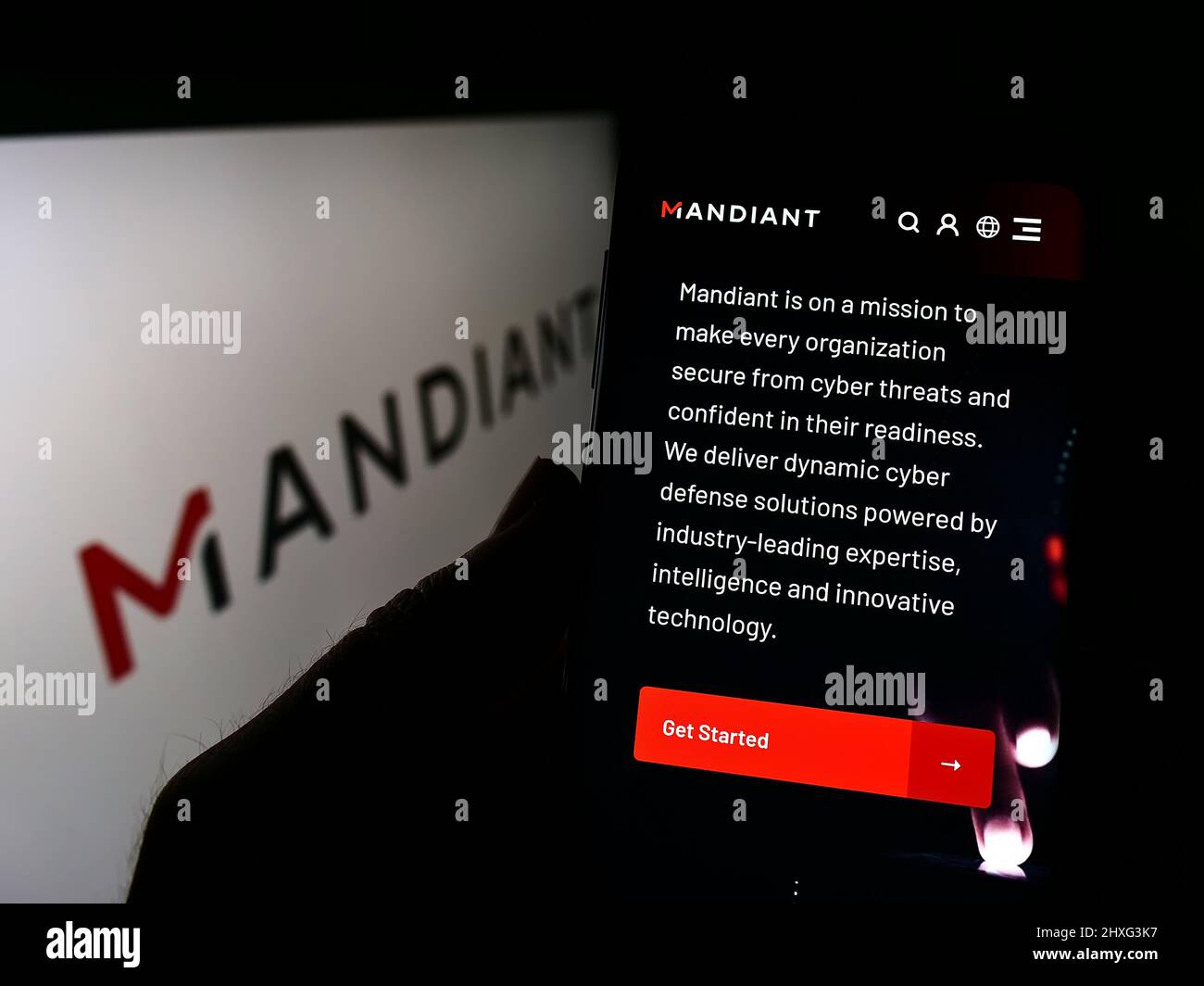Personne tenant un téléphone portable avec le site Web de la société américaine de cybersécurité Mandiant Inc. À l'écran devant le logo. Concentrez-vous sur le centre de l'écran du téléphone. Banque D'Images