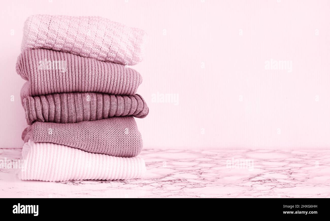 Pile de chandails chauds en tricot rose sur la table Banque D'Images
