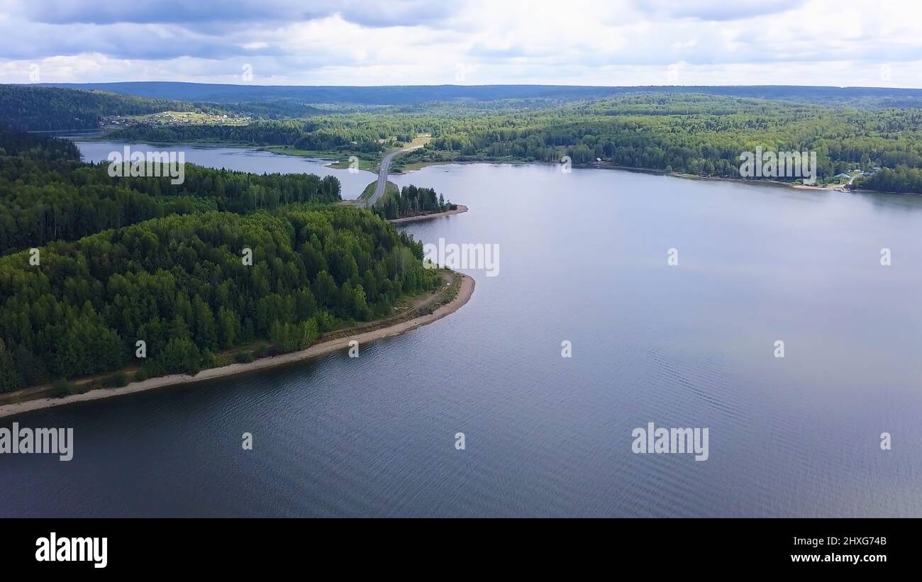 Un immense pont de l'autre côté de la rivière. Attache. Vue plongeante. Un énorme pont sur une grande rivière sur fond de ciel sans nuages et d'une immense forêt Banque D'Images