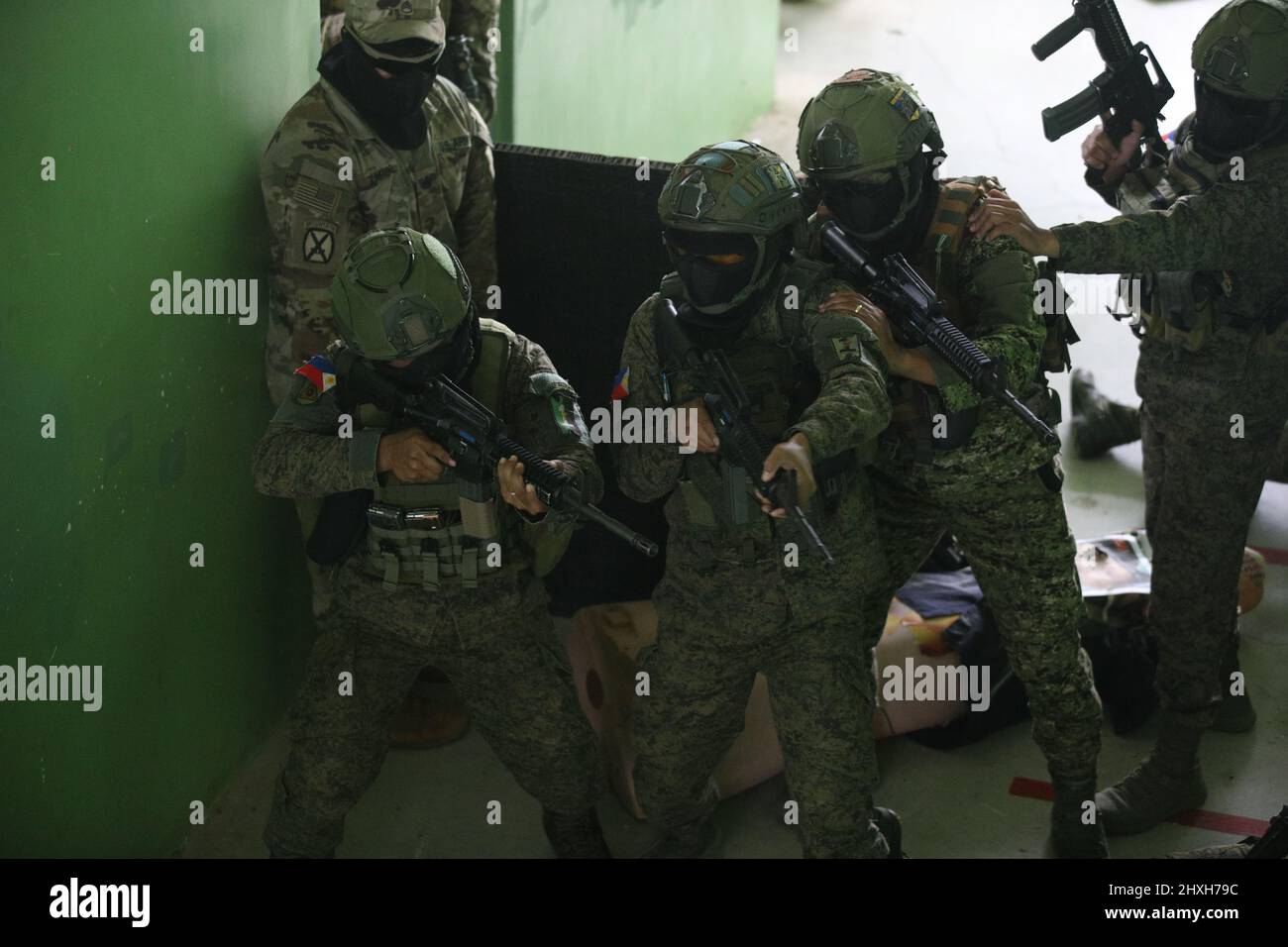Des soldats de l'armée philippine affectés à 1st Brigade combat Team Clear rooms en tant qu'observateur d'entraînement de l'armée américaine de la Compagnie C, 2nd Bataillon, 27th Infantry Regiment, 3rd Infantry Brigade combat Team, 25th Infantry Division, regarde pendant un exercice d'entraînement en terrain urbain à l'appui de Salaknib à fort Magsaysay, Nueva Ecija, Philippines, le 11 mars 2022. Salaknib est un exercice bilatéral annuel mené par l'armée philippine et parrainé par l'armée américaine du Pacifique, conçu pour améliorer la capacité et l'interopérabilité de l'armée américaine et philippine dans toute la gamme des opérations militaires, tout en renforçant les liens entre les deux Banque D'Images