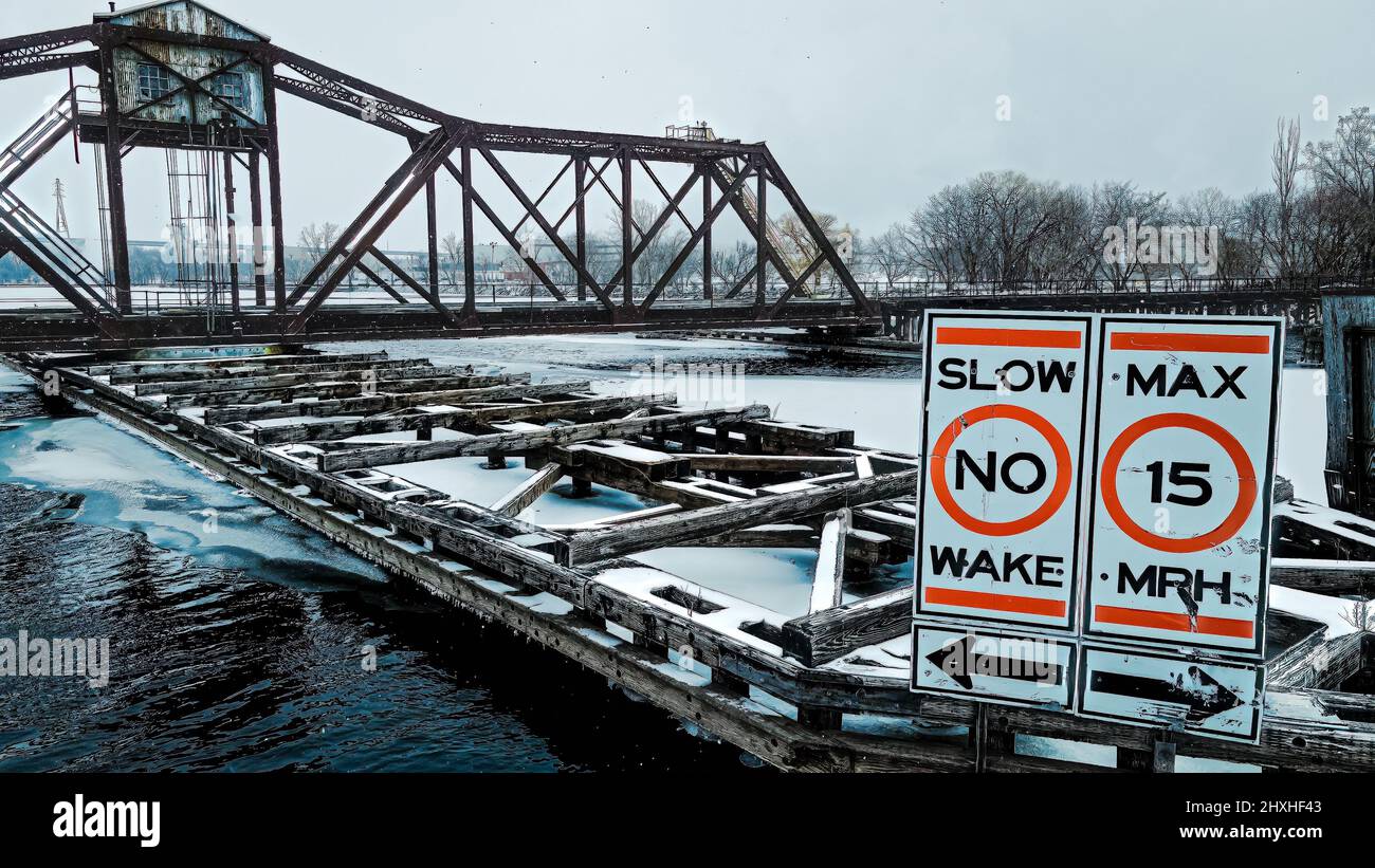 Panneau lumineux pour alerter les plaisanciers de l'ancien pont de balancement rouillé mais pas un problème pendant la scène d'hiver comme il neige. Banque D'Images