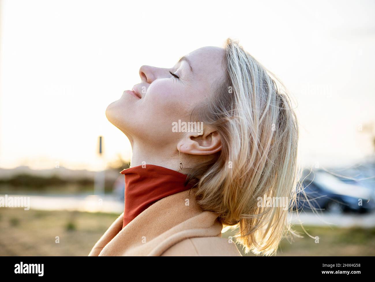 Femme blonde moyenne adulte respirant de l'air frais dans la campagne Banque D'Images