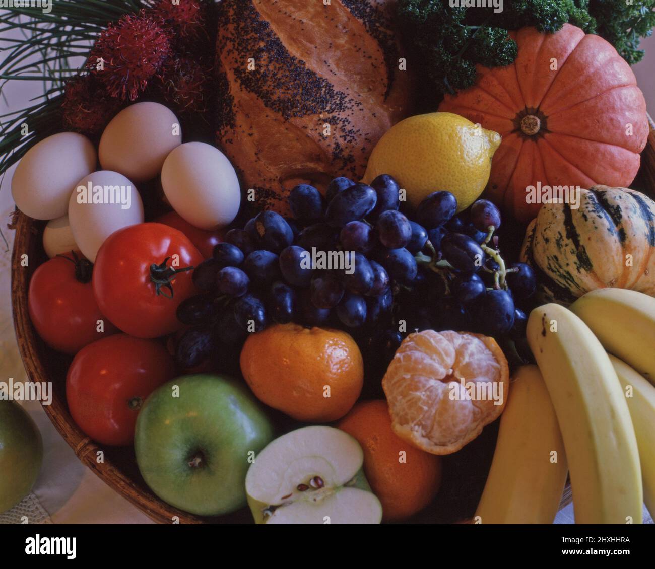 BOL DE FRUITS MÉLANGÉS, PAIN FRAIS, LÉGUMES ET ŒUFS. Banque D'Images