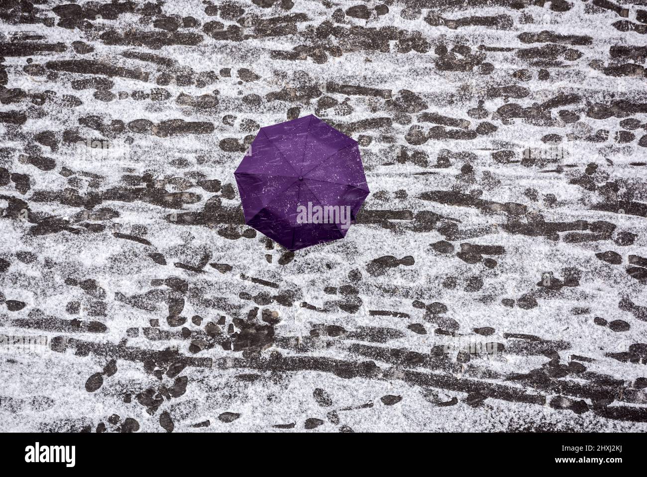 Une personne marchant avec des parasols dans la neige. Vue de dessus. Trottoir recouvert de neige. Dépassement de la norme des précipitations. Danger de marcher dans la neige. Banque D'Images