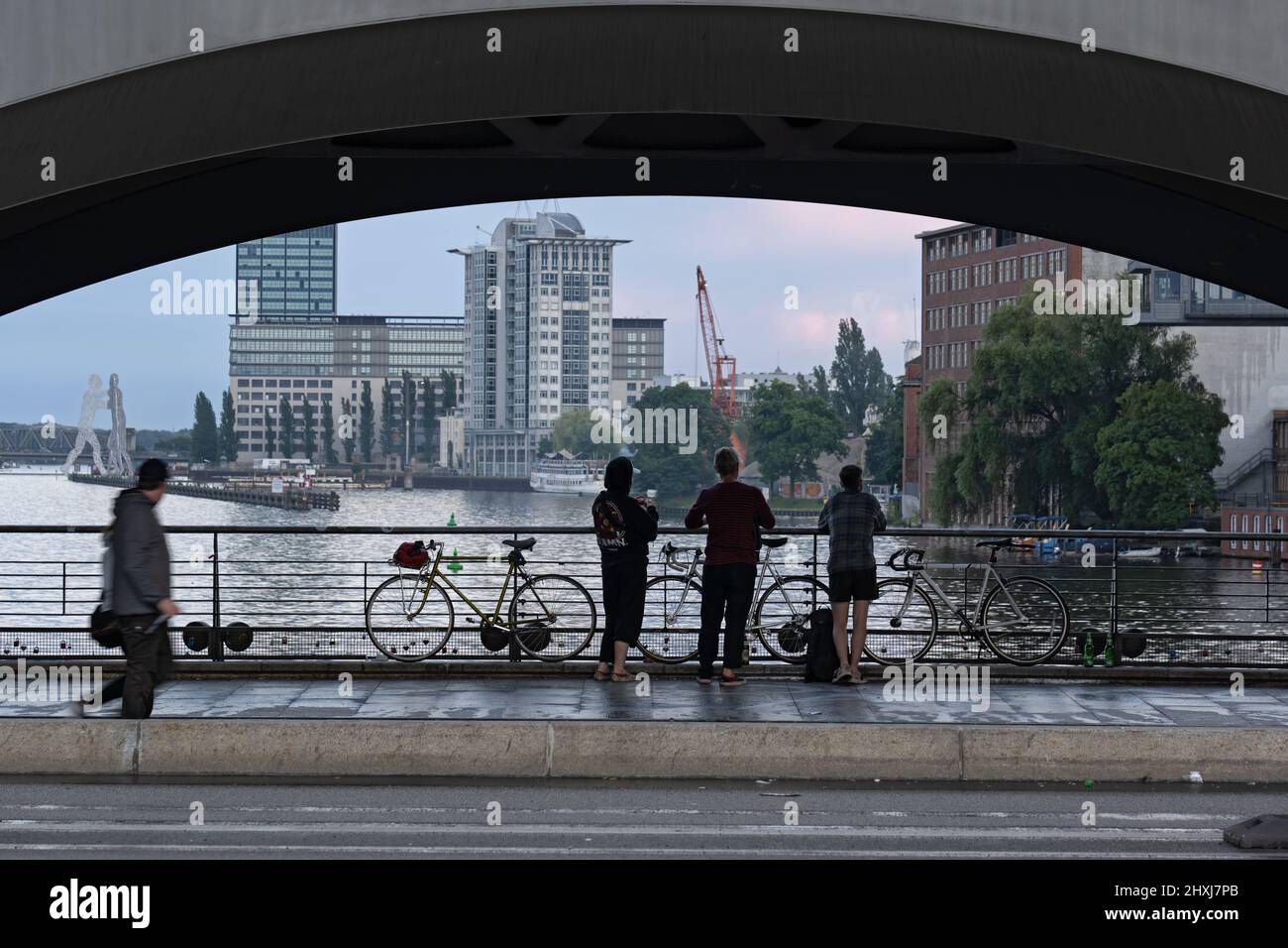 Ville de Berlin, Allemagne, les personnes en vélo faisant une pause et profiter de la vue sur le pont Oberbaum sur la rivière Spree. Banque D'Images