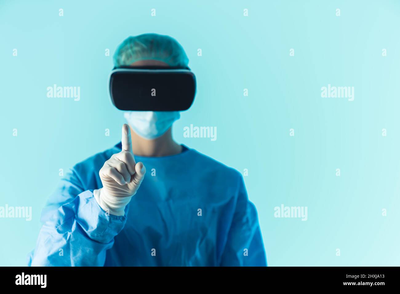 Médecin chirurgien en uniforme et lunettes VR. L'utilisation de la réalité virtuelle en médecine concept. Arrière-plan bleu. Photo de haute qualité Banque D'Images