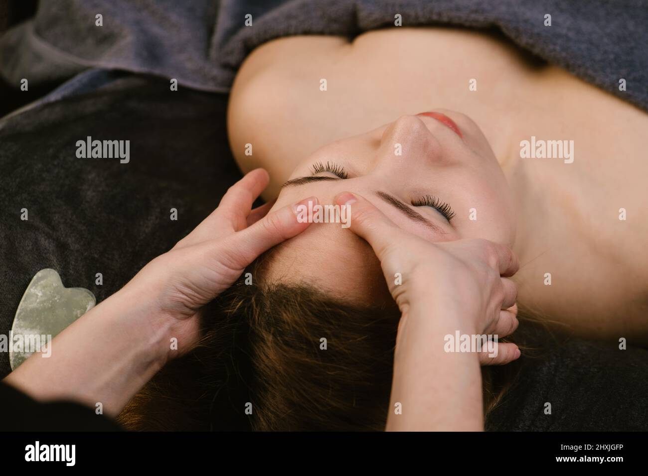 Image à l'envers d'une femme recevant un massage facial dans un salon de beauté Banque D'Images