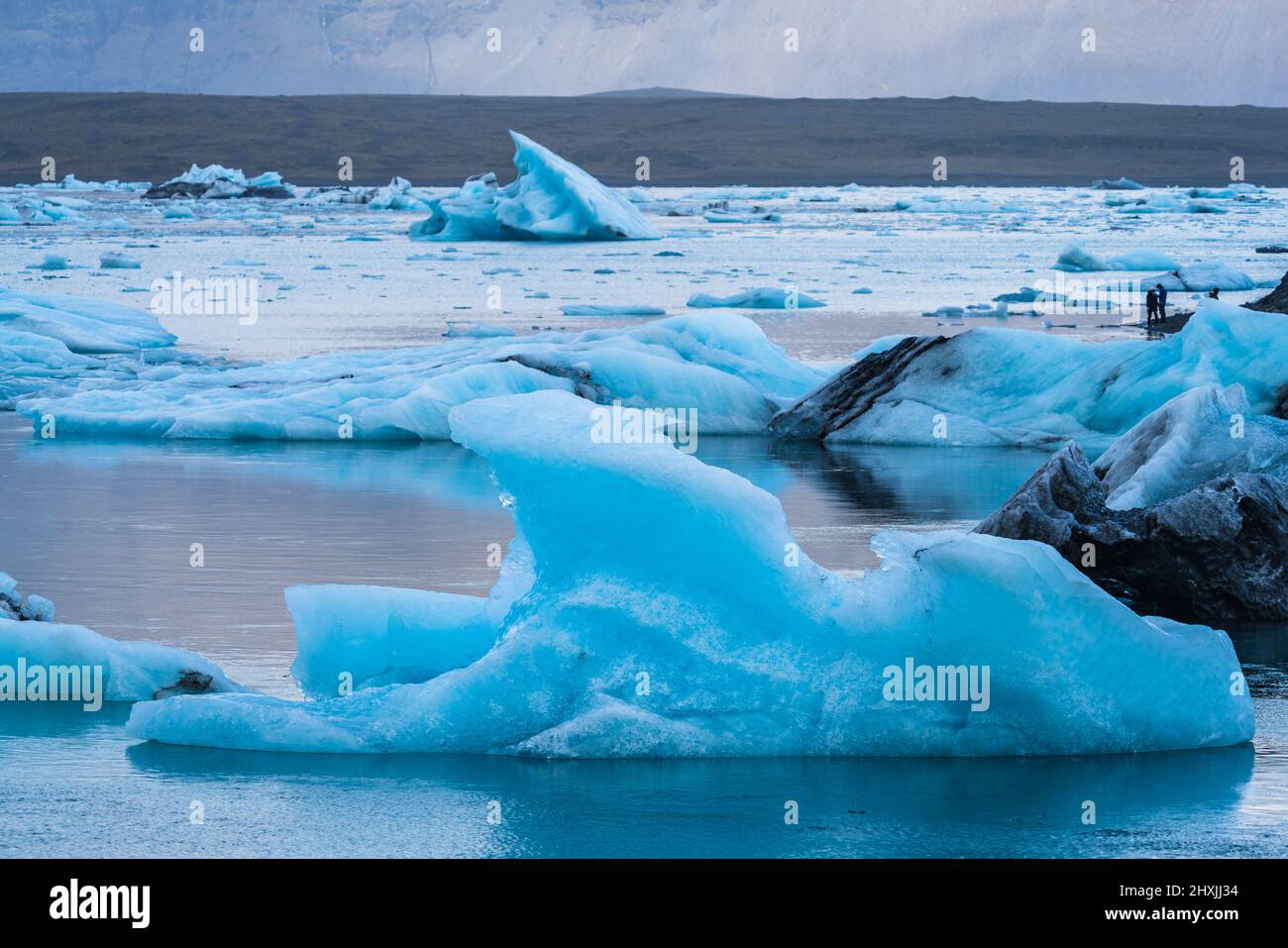Icebergs et silhouettes de touristes sur le lagon de Jokulsarlon Banque D'Images