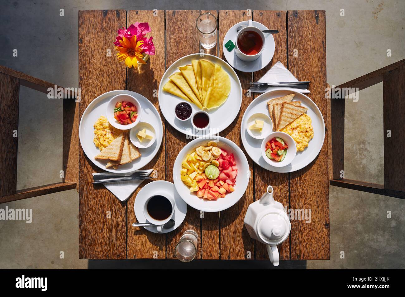 Petit déjeuner à l'hôtel pour deux. Vue sur la table avec œufs brouillés, crêpes, salade de fruits, café et thé. Banque D'Images