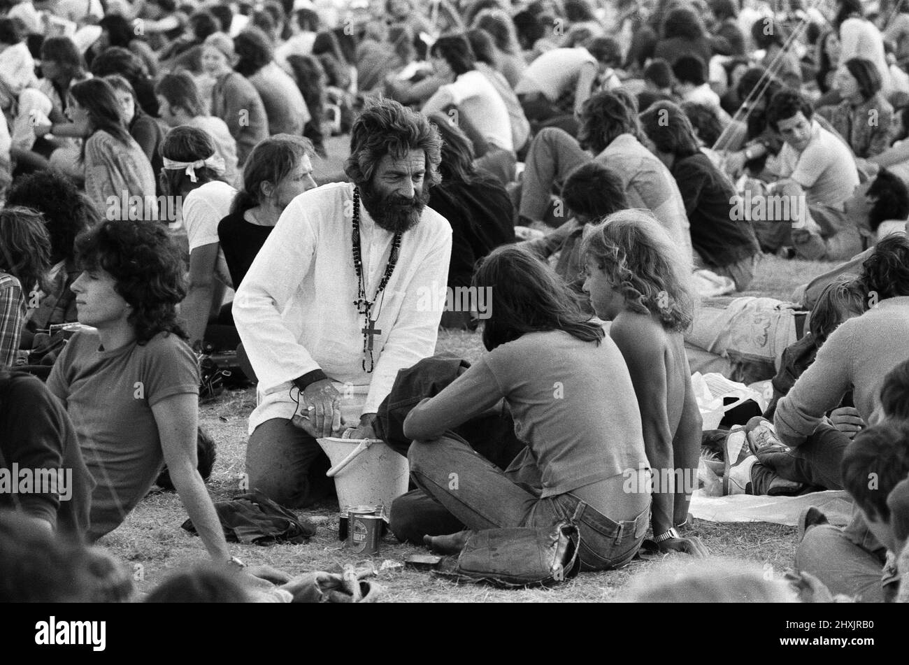 'Mick the Vic', qui est le Rév Michael Scott, Vicaire à l'église St Marc, Reading, visite le site du festival à la lecture, en lavant les pieds des fans de pop. 27th août 1976. Banque D'Images
