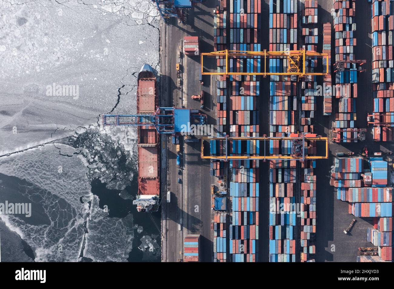 Vladivostok, Russie - 27 janvier 2022 : Vue de dessus du terminal des conteneurs du port maritime. En hiver, un bateau à conteneurs est en train de charger au quai. Banque D'Images