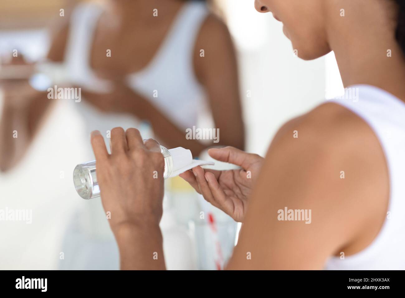 Gros plan d'une femme utilisant de l'eau micellaire et un tampon de coton pour le nettoyage de la peau Banque D'Images