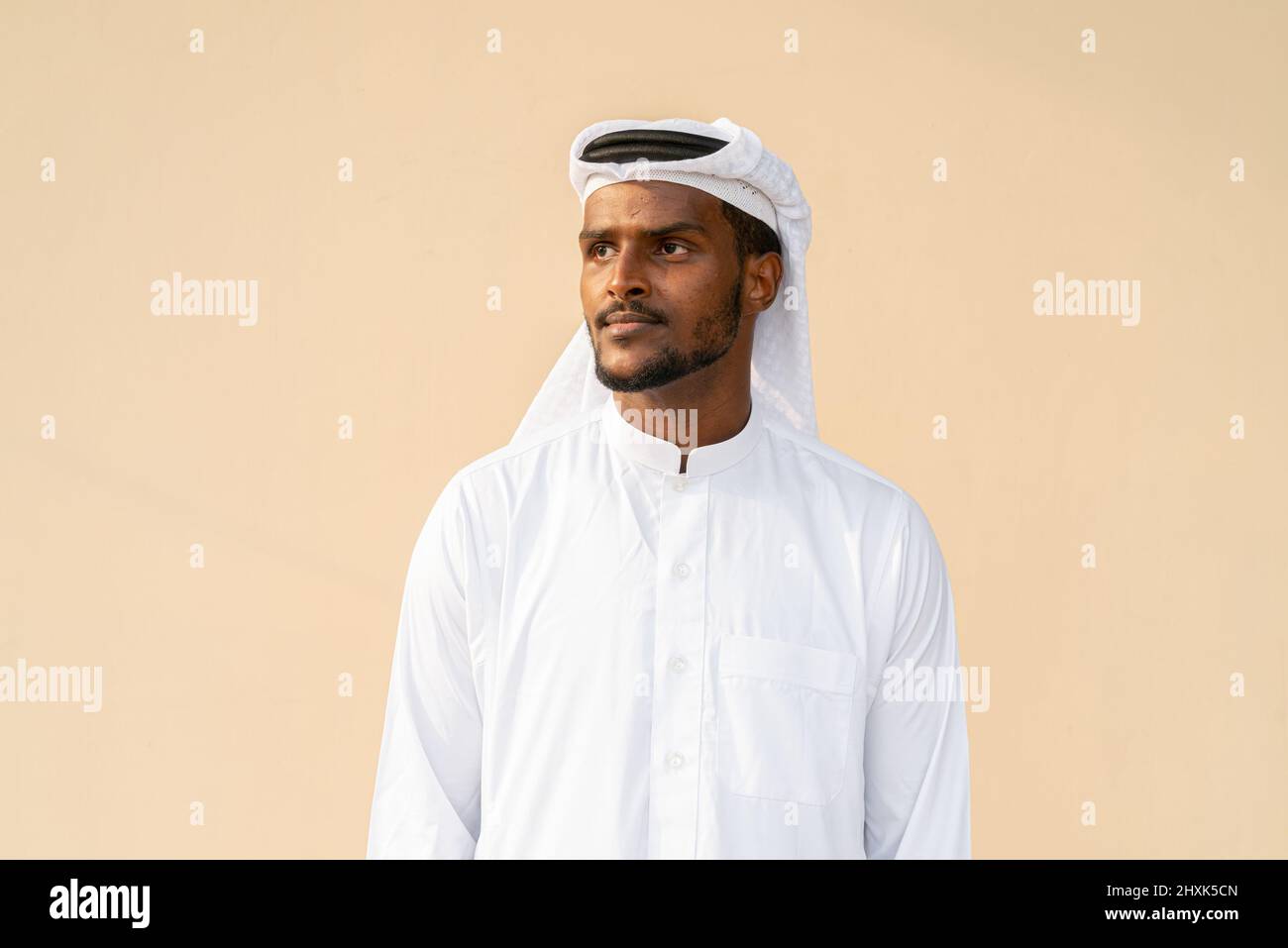 Portrait d'un jeune Africain musulman portant des vêtements religieux, une écharpe contre un mur ordinaire Banque D'Images