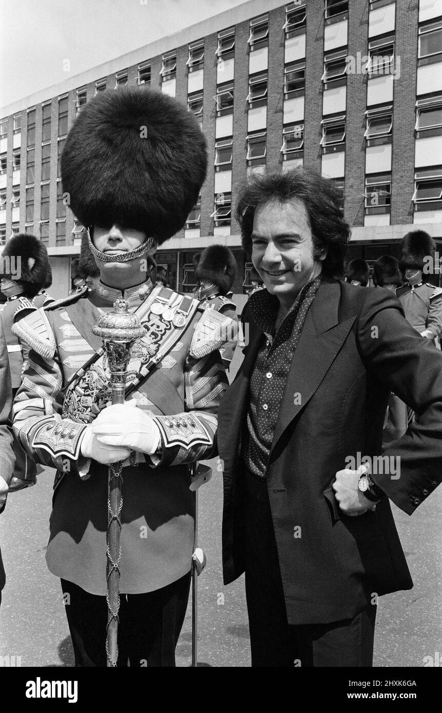 L'animateur Neil Diamond et Lord Tavistock (non représenté) présentent un chèque au bataillon 2nd, Grenadier Guards, à la caserne de Chelsea. Le chèque a été un « merci » pour la performance du corps des tambours au début du concert de samedi dernier à l'abbaye de Woburn, lorsque Diamond a joué à plus de 51 000 personnes. Il sera remis aux Fonds de la Division des ménages (appel du Jubilé d'argent), et est le produit de la vente des programmes Neil Diamond au concert. 7th juillet 1977. Banque D'Images